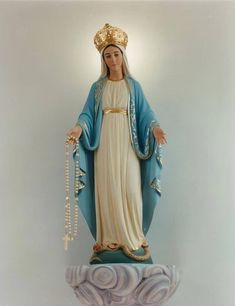 a statue of the virgin mary holding a rosary