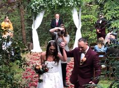 a bride and groom are walking down the aisle at their wedding ceremony in the woods