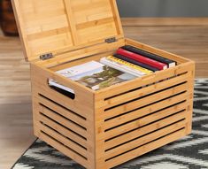 an open wooden box with magazines inside on a rug