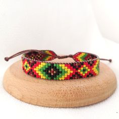 a colorful beaded bracelet sitting on top of a wooden stand