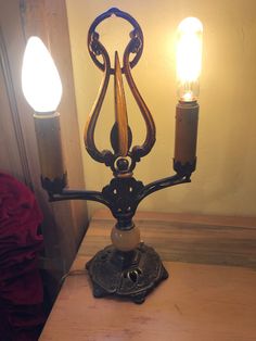 an old fashioned lamp with two candles on it's base sitting on a table