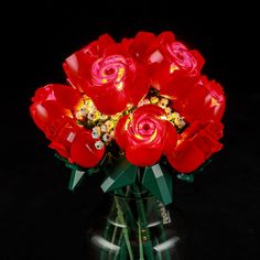 a vase filled with red flowers on top of a table