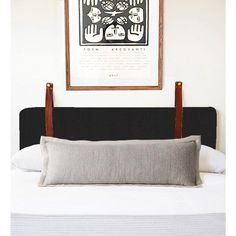 a bed with a wooden headboard and two framed pictures on the wall above it