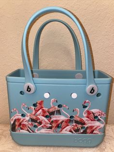 Absolutely beautiful print Depicting a flock of dancing flamingo Aruba Florida Birds Super cute Practical For shopping Carry on Boating Beach Multipurpose Display towels in bathroom Use to n kitchen Beautiful purse handbag From Bogg Bag x Southern Living the Original Bogg Bag in Flamingo Flock of Flamingo features Ethylene vinyl acetate material Water proof Durable washable tip proof Comes with an attached clear plastic insert bag white logo b buttons Snap the buttons on the back of the insert bags into any free hole on the bag Small plastic clear pouch insert approx size 7” x 4.5” x 1” 6” handle drop Approx size of tote 11” x 4” w x 8.5” h Light weight Great gift for collector Add to your collection Wonder idea for a Christmas present Birthday gift From no pets no smoking home Display Towels In Bathroom, Display Towels, Flamingo Gifts, Small Tote Bag, Small Tote, Southern Living, White Bag, Small Bags, Flamingo