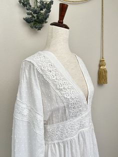 This beautiful white summer dress is the perfect blend of historical and modern styles, featuring classic bishop sleeves, a v-neckline, crocheted lace details, a modern open back and adjustable waist ties. Made of 100% cotton, this dress is ideal for any occasion in which one wants to invoke the feel of a Victorian Era Chemise, or Edwardian Era Lawn Dress in their daily style! This piece is part of our sustainable Secondhand, Vintage, and Upcycled Collection, and thus stock is limited to one! Sizing: Size MBust - 36-38 Inches / 86.3-91.5 CentimetersWaist - 30-32 Inches / 76-81 CentimetersLength - 34.5 Inches / 88 Centimeters Materials:100% Cotton Condition:A+ | No flaws, unworn or barely worn. Bishop Sleeve Dress, Lawn Dress, Crocheted Lace, Medieval Fashion, Bishop Sleeve, Edwardian Fashion, Edwardian Era, White Dress Summer, Curated Vintage