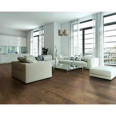 a living room filled with white furniture and large windows next to a wooden floored floor