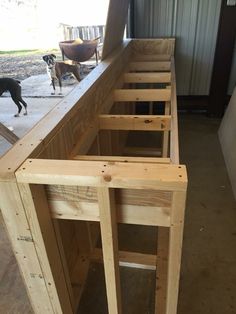 two dogs are standing in the back of a building with wood framing on it's sides