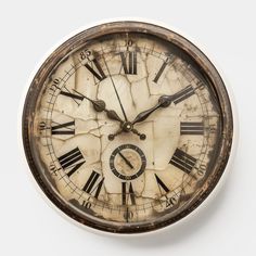 an old clock with roman numerals is shown on a white surface and shows the time