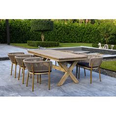 an outdoor dining table with six chairs and a water feature in the back ground area