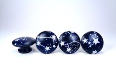 three black and white stars painted on glass knobs