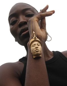 a woman wearing a gold bracelet with a face on it