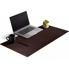 a laptop computer sitting on top of a wooden desk next to a cup of coffee