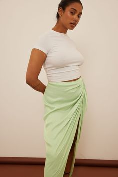 This maxi skirt features a zipper closure on the back, ruching down the front, a side slit and satin fabric. Midi Skirt Green, Green Skirt, Satin Fabric, The Back, Light Green, Maxi Skirt, Midi Skirt, Satin, Zipper