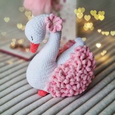 a crocheted swan sitting on top of a bed