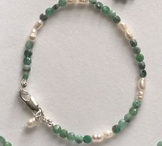 Emerald Sterling Silver and Real Pearl bracelet . This is a Emerald Sterling Silver and Real Pearl bracelet. The bracelet has flat round shape beads with Real Pearls and a Sterling Silver lobster clasp fastening. I can send this Emerald ,Sterling Silver and Real Pearl bracelet to you or to someone else anywhere in the world with your message. Dimensions  Bracelet length 7 1/2 inches  Bracelet width 4 mm  An ideal gift for Birthday, Wedding jewellery bridesmaids gift ,Anniversary gift, Graduation gift, New mom gift, Holiday jewellery and Everyday. I deliver to anywhere in the world. Contact  You can contact me anytime on my shop email with any questions, order and request. Handmade Elegant Beaded Bracelets For Birthday Gift, Elegant Handmade Beaded Bracelets For Birthday Gift, Elegant Handmade Beaded Bracelet For Birthday Gift, Adjustable Sterling Silver Bracelet With Polished Beads For Gift, Adjustable Green Sterling Silver Bracelet Gift, Adjustable Polished Beads Sterling Silver Bracelet Gift, Adjustable Sterling Silver Bracelet With Polished Beads, Hand-strung Pearl Bracelet Gift, Wedding Bracelets With Sterling Silver Clasp And Round Beads