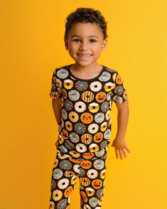 Popoki Halloween is here! Two piece short sleeve shirt with pants pajama set. Our exclusive hand drawn print features a black background with spooky fun Halloween themed donuts of Jack-o-lantern, black cat, mummy, spiderwebs, sprinkles and stripes. Earth-friendly, hypoallergenic bamboo viscose extra gentle on sensitive and eczema-prone skin. Breathable bamboo fabric adjusts to keep children snuggly and warm in winter, and cool and comfortable in summer. No snaps, buttons, or interior tags to rub Halloween Donuts, Cat Sanctuary, Cat Pajamas, Bamboo Pajamas, One Piece Pajamas, Twirl Dress, Mens Pajamas, Bamboo Fabric, Earth Friendly