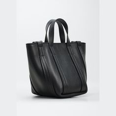 Balenciaga tote bag in grained calf leather Flat top handles; side flat straps  Detachable, adjustable crossbody strap Open top with center/zip magnetic closures  Interior, one zip pocket  Approx. 8.6"H x 7.4"W x 3.7"D Made in Italy Balenciaga Day Bag, Balenciaga Tote Bag, Balenciaga Large Bag, Balenciaga Top Handle Bag, Balenciaga Bag Strap, Balenciaga Tote, Gunmetal Hardware Tote Shoulder Bag For On-the-go, Flats Top, Leather Flats