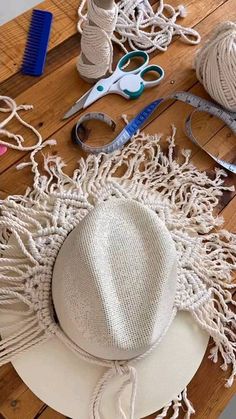 the hat is sitting on the table next to some scissors and other crafting supplies