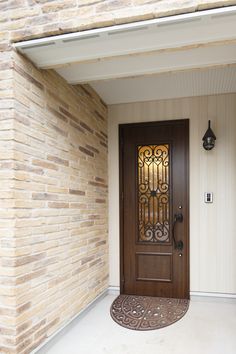 the front door is brown and has a decorative glass panel