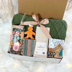 a gift box filled with assorted items on top of a white furnishing