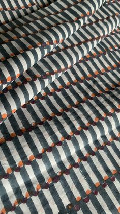 an orange and black striped fabric with circles on it's edges is shown in close up