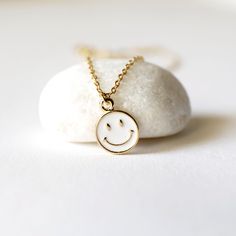 "Beautiful and lovely tiny happy face charm necklace. Made of white enamel gold smiley face charm with skinny gold plated brass chain. Soft and warm. Great for gift , everyday or special occasion. Your item will ship in a gift box. Please feel free to contact me if you have any question. ♥ Length 14\" -20\" chain ♥ Charm 3/8\" ♥ Gold plated over brass / white enamel ♥ Delivery Time Fast shipping within 1 - 3 days ♥ See more Rudiana Accessories Rudiana.etsy.com" Everyday Cute Nickel-free Charm Necklaces, Dainty White Necklace For Best Friend Gift, Cute White Nickel-free Charm Necklaces, Cute Everyday Necklace With Adjustable Chain, Trendy 14k Gold Filled Charm Necklaces For Gifts, Trendy 14k Gold Filled Charm Necklaces As Gift, Everyday White Charm Necklace In 14k Gold Filled, Everyday White 14k Gold Filled Charm Necklaces, Cute Everyday White Necklace