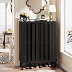 a black cabinet with shoes on it in front of a white wall and a mirror