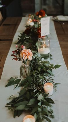 a long table with candles and flowers on it