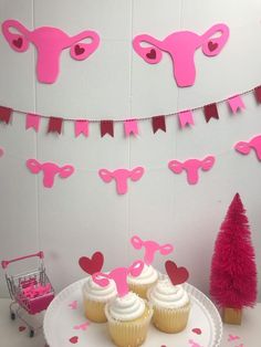 cupcakes are on a plate with pink decorations