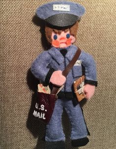 a toy soldier holding a mail bag and wearing a hat with the u s mail on it