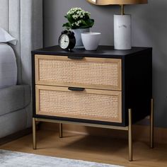 a nightstand with two drawers and a clock on top