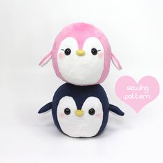 two stuffed penguins sitting next to each other on a white background with a pink heart