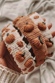 someone is holding two crocheted animal mittens in their hands, both with buttons on them