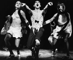 an old black and white photo of three people on stage with their arms in the air