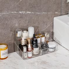 a bathroom counter with cosmetics and skin care products on it