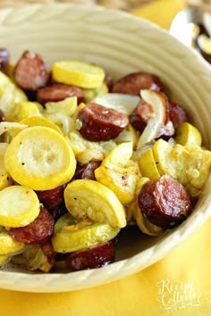 a bowl filled with sliced up bananas and sausages on top of a yellow table cloth