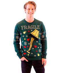 a man wearing a green christmas sweater with a gold bell on it's chest