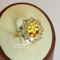 Thank you for coming in!This Vintage Ring has a strong striking yellow sapphire as its center piece. The sapphire is bezel set into a fancy setting with 8 heart and 8 round diamonds totaling 1.8 carats!Ring Size: 7.75Total Weight: 9.58 gramsPrecious Metal: 18k solid goldPrecious stones:-Yellow Sapphire: 2.92 carats, 9mm x 7.3mm-White Round Diamonds: 1.8 ctHallmark: A18K Luxury Multi-stone Yellow Diamond Ring, Yellow Multi-stone Sapphire Ring, Luxury Yellow Multi-stone Jewelry, Luxury Yellow Sapphire Multi-stone Ring, Yellow Sapphire Ring With Center Stone In Yellow Gold, Yellow Multi-stone Diamond Ring In Fine Jewelry Style, Yellow Multi-stone Diamond Ring Fine Jewelry, Elegant Multi-stone Yellow Sapphire Jewelry, Yellow Multi-stone Diamond Ring