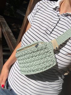 a pregnant woman holding a crocheted purse