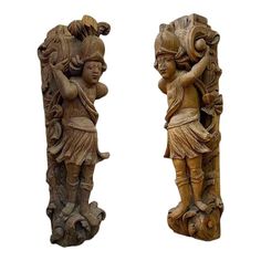 two carved wooden sculptures are shown against a white background, one is holding a vase and the other is carrying a bird