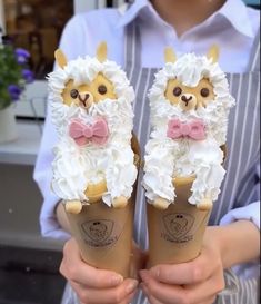 two people holding ice cream cones with llamas on them