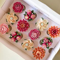 cupcakes decorated with flowers are in a box