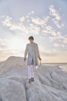 This set features all over mirror work on a raw silk base. It is paired with a grey silk kurta and white straght pant. Complementing stole is also available.From Seema Gujral's Elements collection. DELIVERY TIMEPlease allow 6-8 weeks for your outfit to arrive. FABRIC DETAILSSherwani - Raw Silk Kurta - Silk Trouser - Cotton Dupatta - Tissue Organza Professional cleaning only. Mirror Work Sherwani Mens, Silver Bollywood Kurta With Mirror Work, White Chanderi Sherwani With Mirror Work, Mirrorwork Kurta For Men, White Semi-stitched Sherwani With Mirror Work, Raw Silk Kurta, Grey Mirror, Cotton Dupatta, Silk Kurta