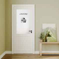 an empty room with a white door and wooden bench in front of the door that is open