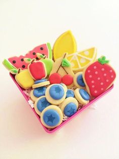 a pink tray filled with lots of different types of cookies on top of a white table