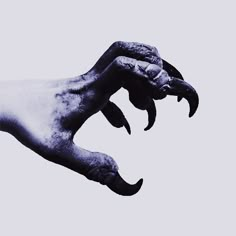 a person's hand holding something in the air with it's claws spread out