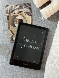 a kindle with the words hello, witching on it next to other items