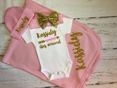 "Personalized baby girl outfit \"has arrived\" shown in glitter gold and neon pink hearts! LS- Long sleeve SS- Short sleeve {OPTIONS} Pink and gold headband-one size stretchy (will not fit preemie but I will send a different pink bow for preemies) Pink beanie (0-6 months) with custom name. Pink cotton receiving blanket with custom name(30x40) . {COLORS} Colors will be as shown in the main photo unless another color is requested (pink & gold) Please do not leave notes about colors if you want Custom Baby Onesies, Cricut Baby, Custom Baby Clothes, Preemies, Personalized Newborn, Custom Onesies, Business Packaging, Girls Coming Home Outfit, Baby Girl Outfit