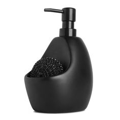 a black soap dispenser sitting on top of a white counter next to a brush