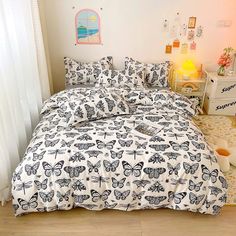 a bed with butterflies on it in a bedroom next to a white dresser and window